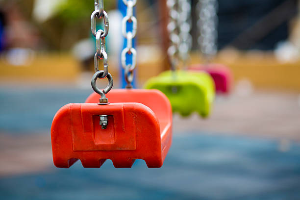 Close up of empty swing in a playground stock photo