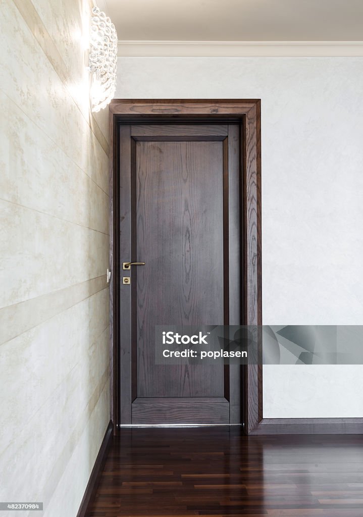 Wooden entrance door Brown wooden entrance door and white wall in home interior 2015 Stock Photo