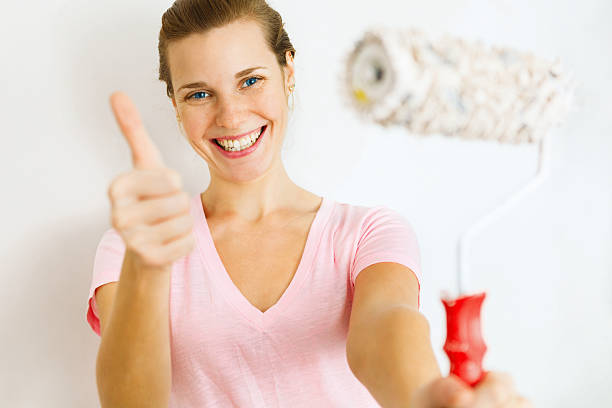 istock Happy Woman showing thumb up with roller brush. 482372459