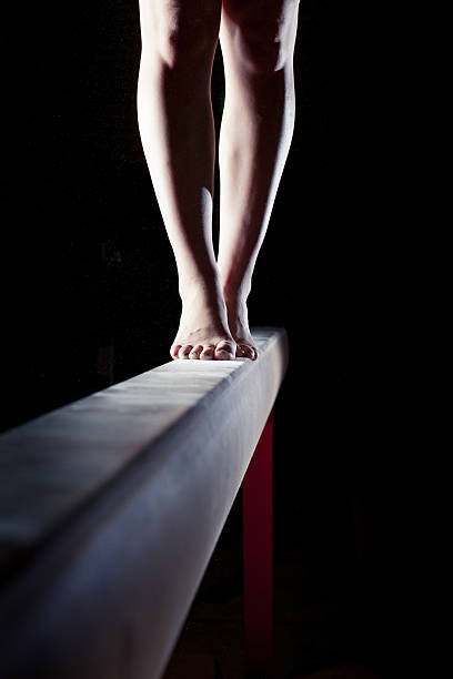 feet of gymnast on balance beam stock photo