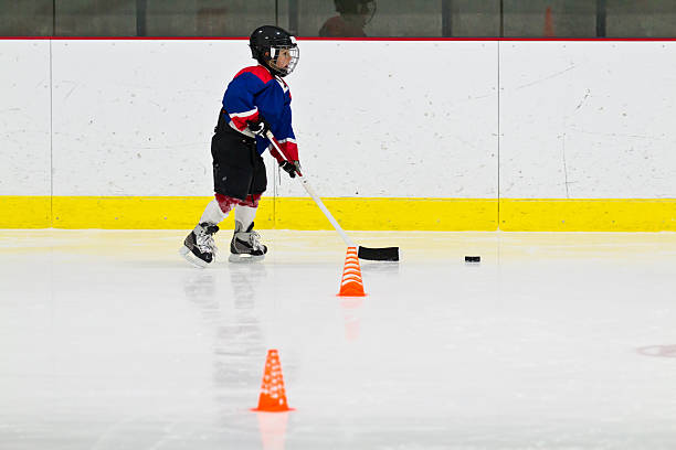 Child practices stickhandling at ice hockey practice stock photo