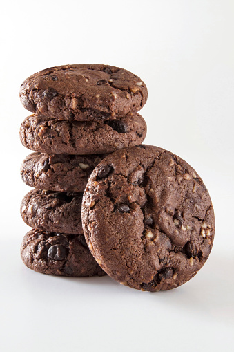 Six pieces of chocolate chip cookies with hazelnut and dark chocolate pieces are Isolated on white.