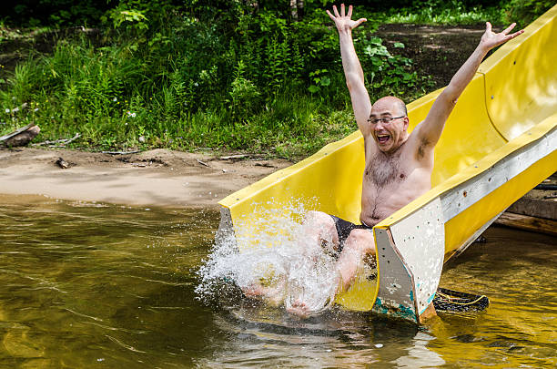 Floating on the yellow mattress three young adults are making bubbles in the sea