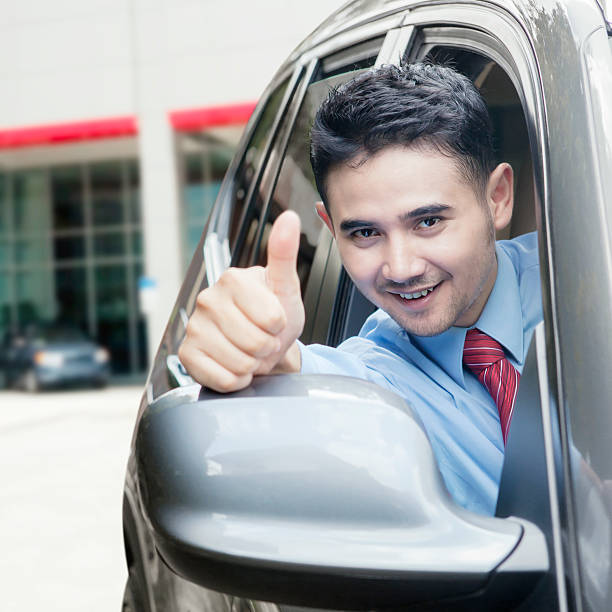 istock Young man shows thumb up in the car 482391696