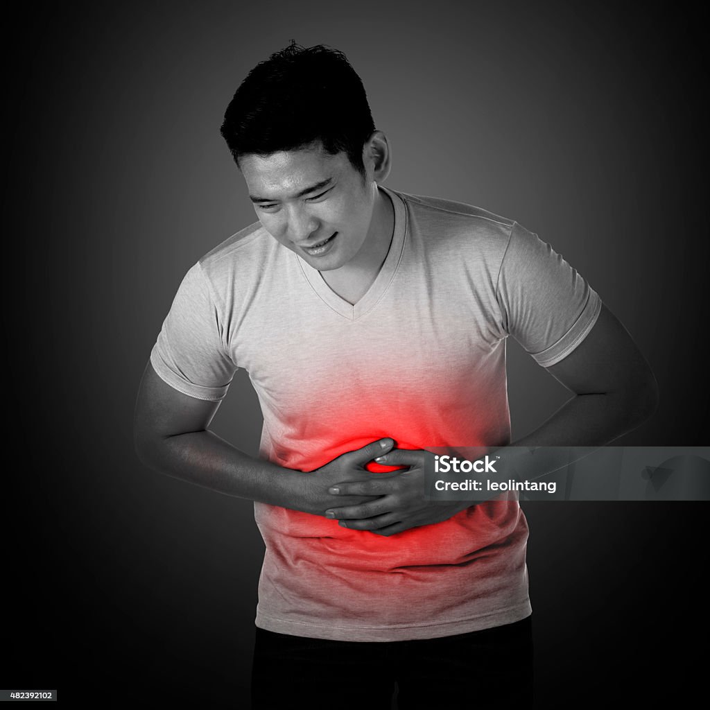 Asian man have stomach ache Young asian man have stomach ache, with uneasy face 2015 Stock Photo