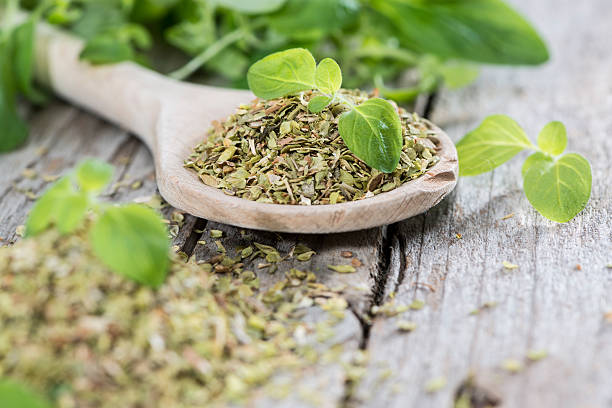 Wooden Spoon with shredded Oregano Wooden Spoon with shredded Oregano (close-up shot) oregano stock pictures, royalty-free photos & images