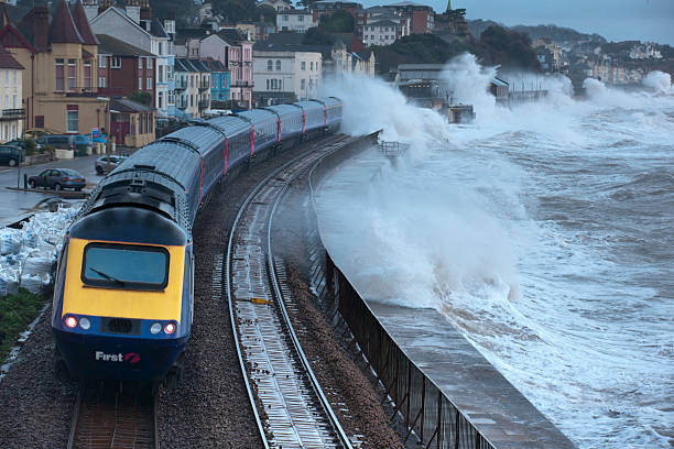 Intercity train getting a soaking at Dawlish during severe storm Dawlish,England - February 3, 2014: An intercity train getting a soaking at Dawlish less than 2 days before another storm closed the line due to severe damage a few hundred metres away. ballast water stock pictures, royalty-free photos & images