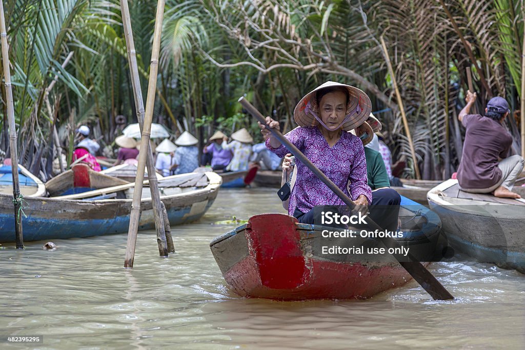 Vietnamese People on Boats Mekong Delta, An Giang, Vietnam An Giang, Vietnam - April 16, 2013: Vietnamese people on a small boat at Tra Su Natural Reserve in Mekong Delta, An Giang, Vietnam. Adult Stock Photo