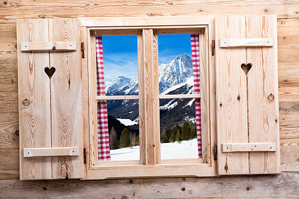 Wooden window with snowy mountains as reflections