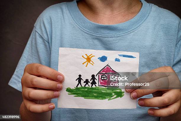 Child Holds A Drawn House With Family Stock Photo - Download Image Now - Child's Drawing, House, Boys