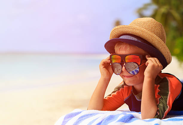 istock cute little boy trying on sunglasses at beach 482399362