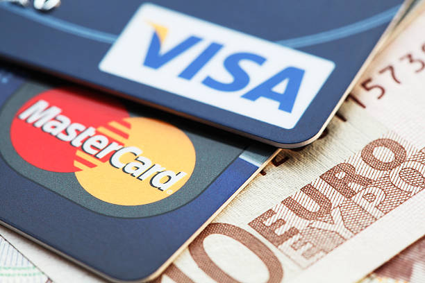 Moscow, Russia - March 23, 2014: Visa and MasterCard credit cards against Euro banknotes. Visa and MasterCard are major credit card companies in the world.
