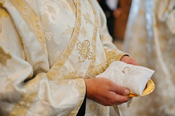 istock wedding rings at hand of priest 482404832