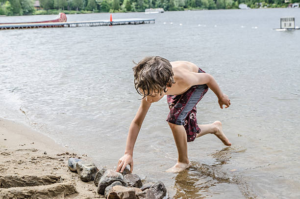 istock Little boy building castle with sand and rock 482405464