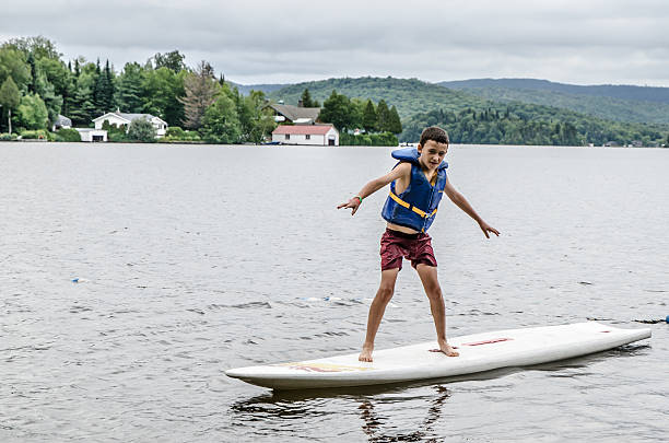 istock Little boy balancing on surf board 482406630