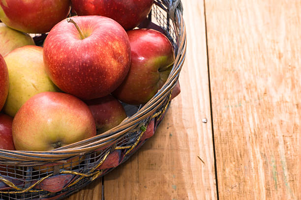 istock Red apples in basket on brown wooden background 482406754