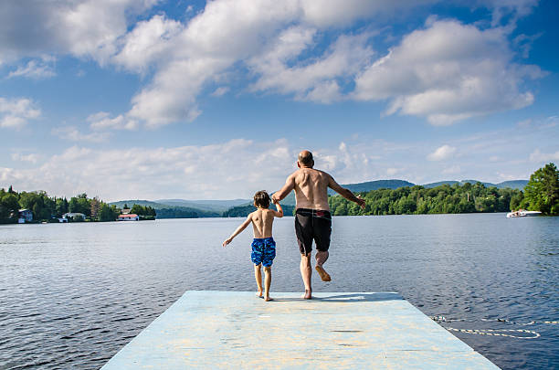 istock Father and son jumping in lake 482407042