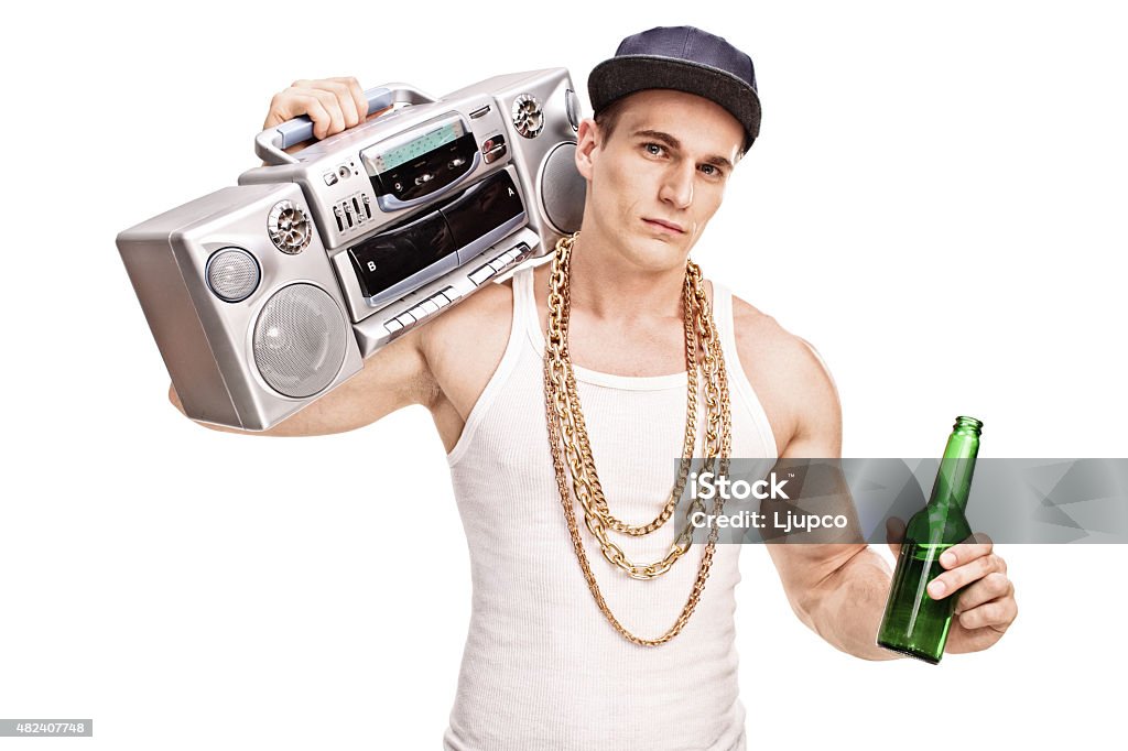 Rapper carrying a ghetto blaster and holding beer Young male rapper carrying a ghetto blaster over his shoulder and holding a bottle of beer isolated on white background Beer - Alcohol Stock Photo