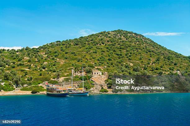 Two Boats Moored At Green Island With Ancient Ruins Stock Photo - Download Image Now