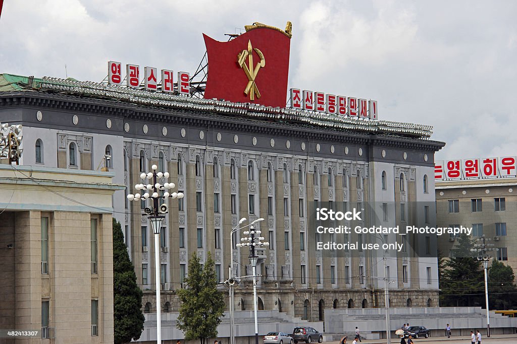 North Korea DPRK: Ministry of Foreign Trade Pyongyang, North Korea - August 15, 2013: Locals walk across Kim Il Sung Square and pass the Ministry of Foreign Trade building. This imposing example of Stalinist architecture is beside the Grand People's Study Hall. Horizontal Stock Photo