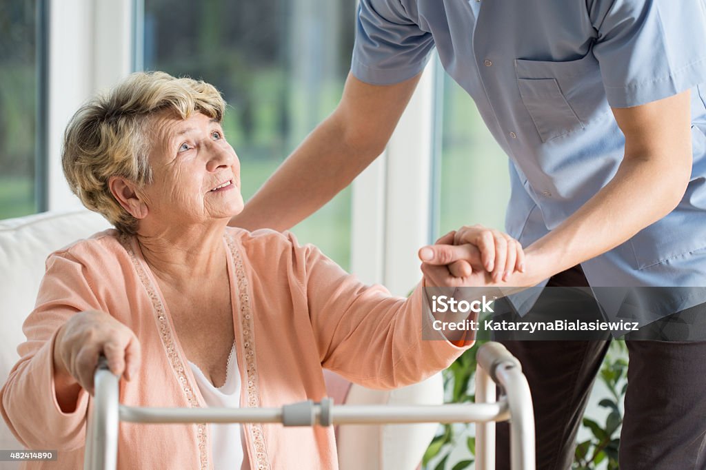 Help with walking Old woman gets help with walking from a nurse Assistance Stock Photo