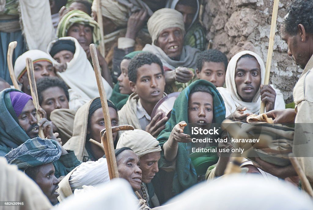 Volunteers hand out food to pilgrims after Christmas, Lalibela, Ethiopia. Lalibela, Ethiopia - January 7th, 2014: Unidentified volunteers hand out food to pilgrims after celebration of Orthodox Christmas on January 7, 2014, Lalibela, Ethiopia. Famine Stock Photo