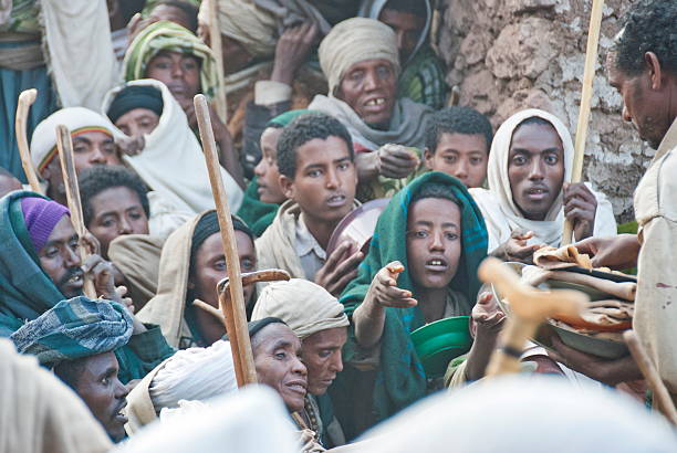 Volunteers hand out food to pilgrims after Christmas, Lalibela, Ethiopia. stock photo