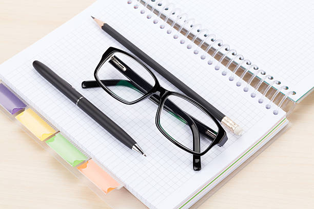 istock Office table with glasses over notepad, pen and pencil 482421408