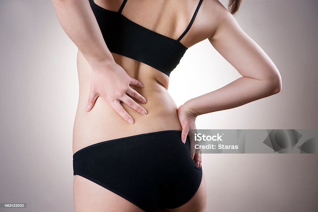 Woman with backache. Pain in the human body Woman with backache. Pain in the human body on gray background 2015 Stock Photo