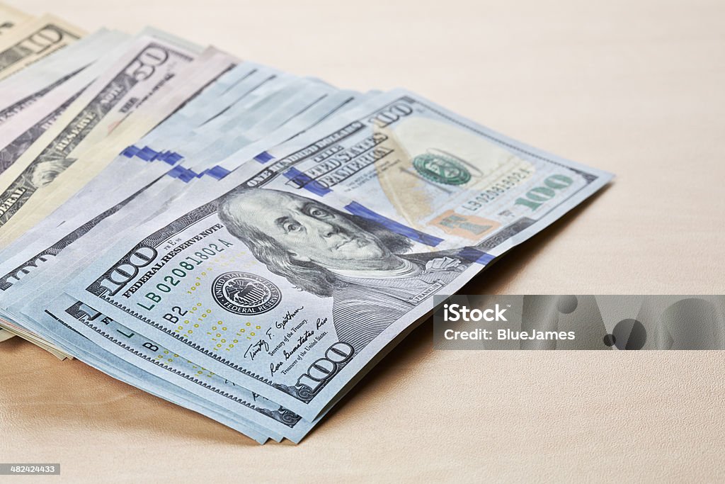 Dollars notes on wooden table Dollars notes on wooden table. Low DOF American One Hundred Dollar Bill Stock Photo