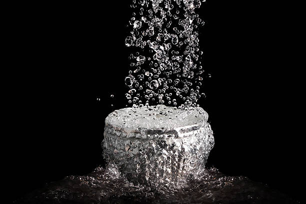 The rapid flow of water into the silver bowl