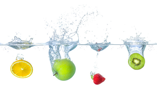Fresh fruits falling into water with splashes