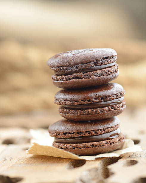 tre macaroons (biscotti) con cioccolato sovrapporre insieme - brown chocolate candy bar close up foto e immagini stock
