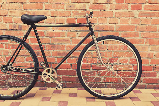istock Old style singlespeed bicycle against brick wall, tinted photo 482429484