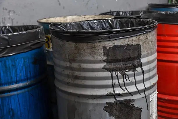 old bins of oil, used for trash arranged in rows