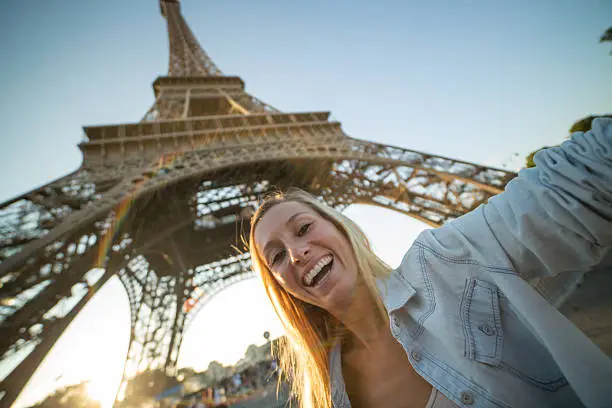 Photo of Cheerful girl taking selfie in Paris-Eiffel tower