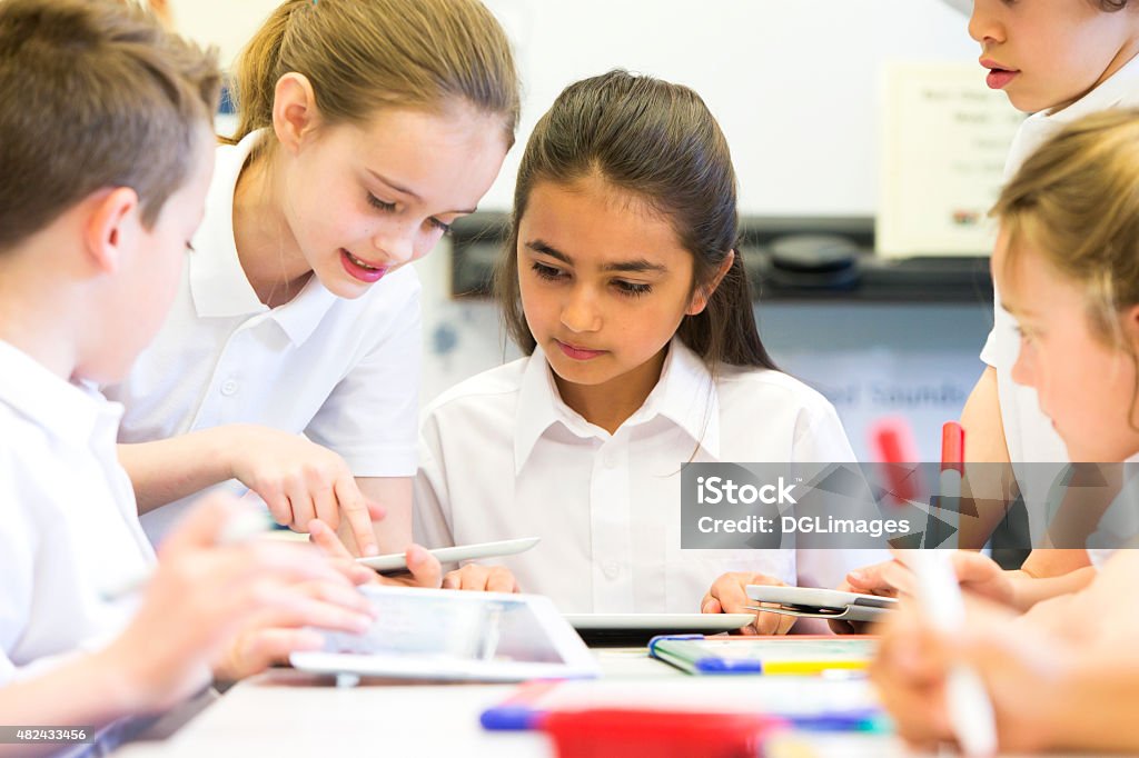 Happy at School A group of school children can be seen working on digital tablets, they are all working happily. Child Stock Photo