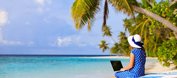 istock young woman with laptop on tropical vacation 482435224