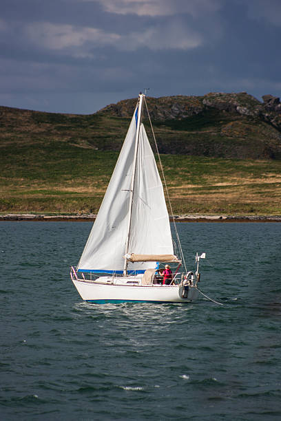 Yacht sailing from Howth with Irelands Eye in the background stock photo