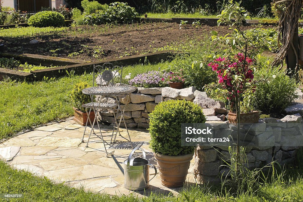 Iron chair and table in the garden Sunny place in the garden for relaxing. Arranging Stock Photo