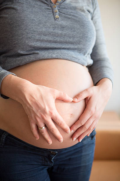 istock Pregnant woman making heart shape with hands on belly 482437907