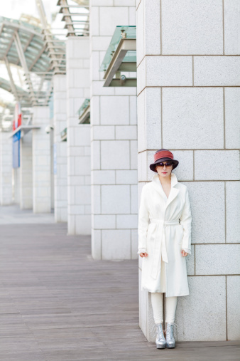 portrait of a woman leaning on a shopping mall column. Outdoor portrait