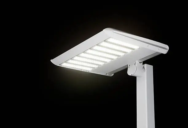 A new, illuminated, LED streetlight against a black night sky. LEDs represent the latest in lighting technology, although initially more expensive than traditional lights, LEDs are being considered for energy efficient installations around the world. This would work equally well for a parking lot concept.