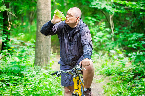 istock Tired man with bicycle in the park 482441248