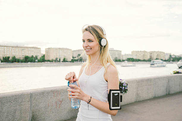 Beautiful Woman Relaxing After Workout Drinking Water Beautiful woman relaxing after workout, drinking water. russian culture audio stock pictures, royalty-free photos & images