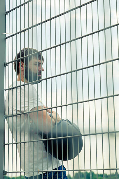istock Biker with beard near a fence with a helmet 482445786