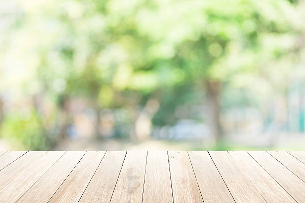 istock Green abstract blur nature background with wooden floor 482446138