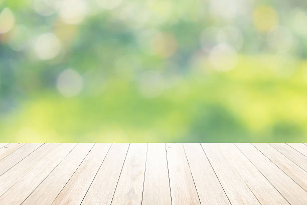 istock Green abstract blur nature background with wooden floor 482446140