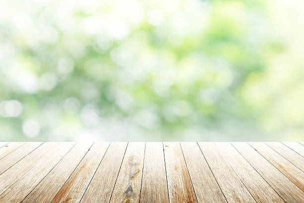 istock Green abstract blur nature background with wooden floor 482446566