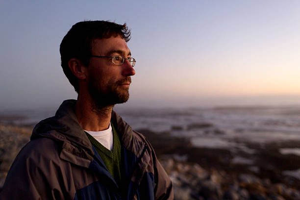 istock Portrait of a thinking man looking into sunset coastline 482446666
